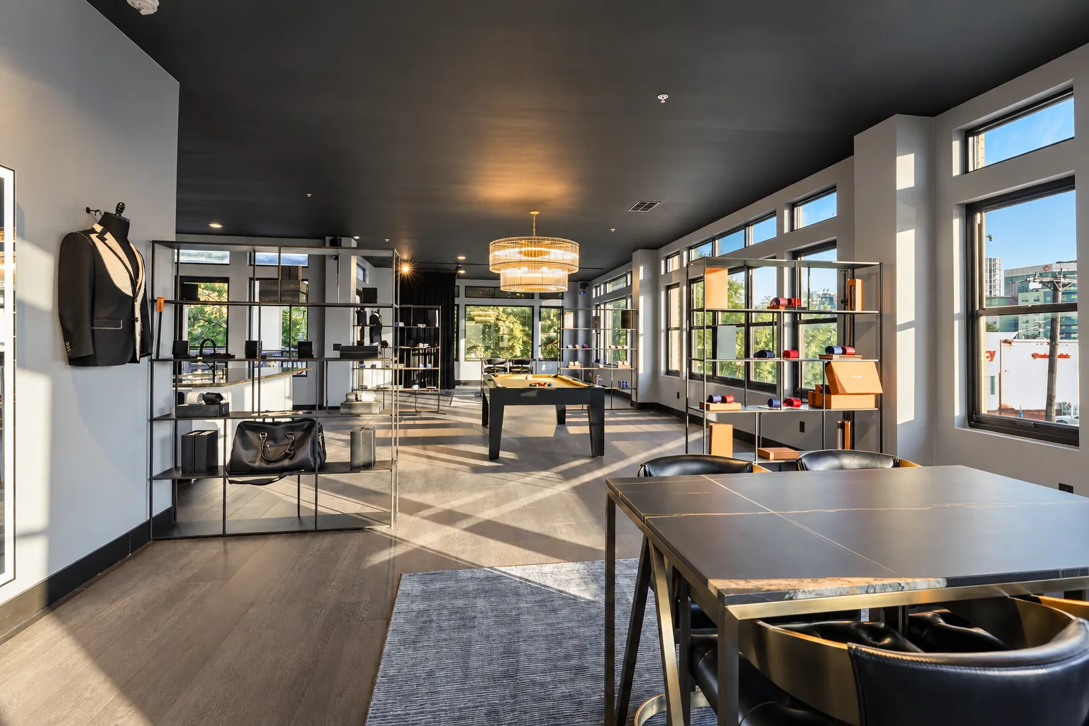 The Enzo Custom Dallas showroom, with warm sunlight, leather seating, a consultation table and tailoring displays